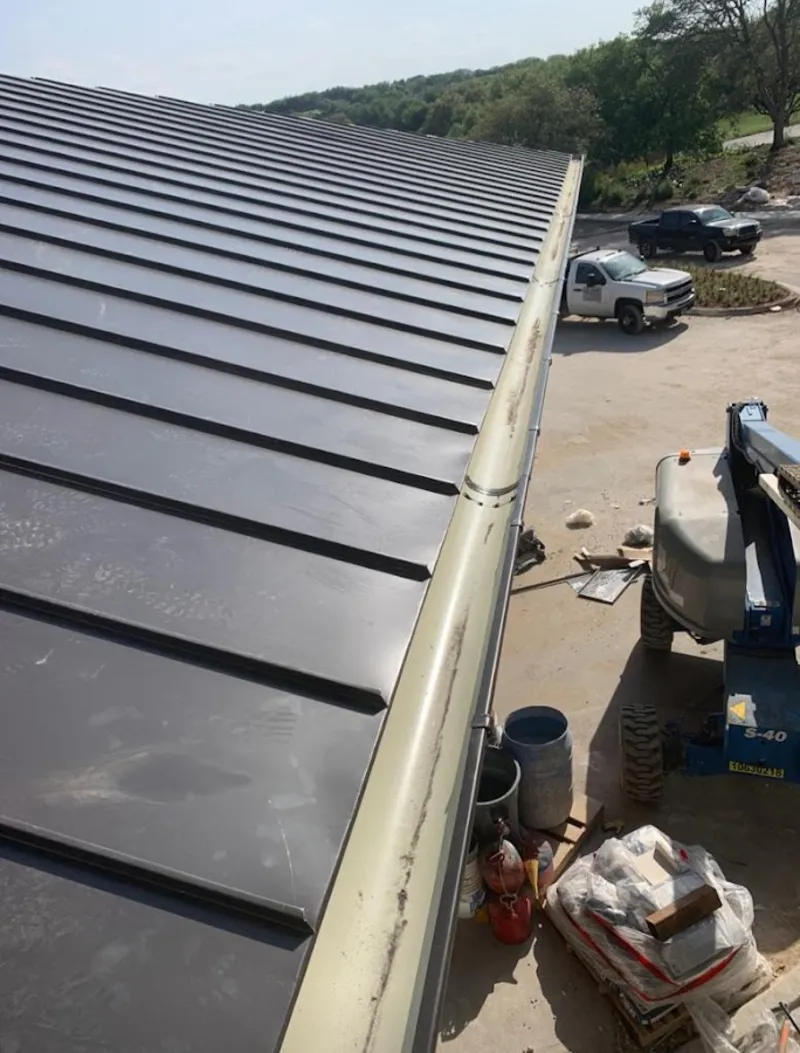 Standing seam panel and gutter detail on a metal roofing jobsite in Corcoran